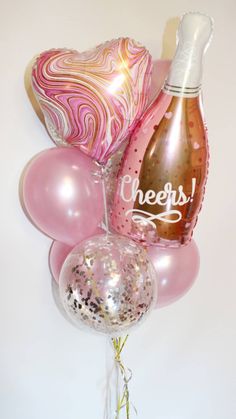 balloons, champagne and confetti are arranged in a vase