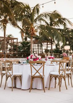 an outdoor dining area with tables and chairs set up for a formal function at the beach