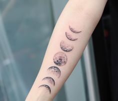 a woman's arm with three phases of the moon tattoo on her left arm