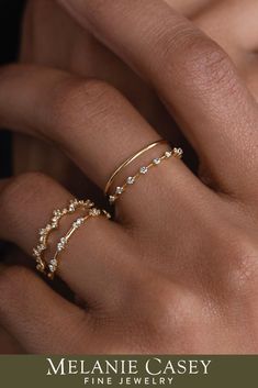 a woman's hand with two gold rings on her fingers and the words melanie casey fine jewelry