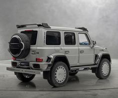 the mercedes g - class suv is parked in an empty room with no one around