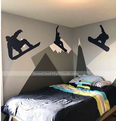 a bedroom with snowboarders on the wall and mountains painted on the walls behind it