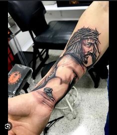 a man with a jesus tattoo on his arm