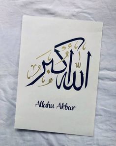 arabic calligraphy on white paper with blue and gold writing in two languages, including the name alhan albaar