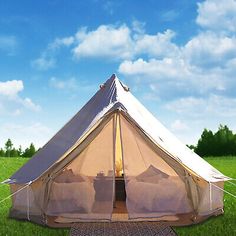 a tent set up in the middle of a field with grass and blue sky behind it