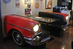 an old car is on display in a museum with other cars and memorabilia around it