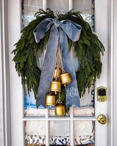 a wreath with bells hanging on the front door