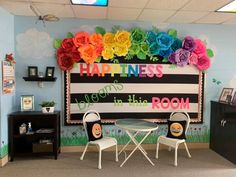 a classroom decorated with colorful paper flowers on the wall and chairs in front of it