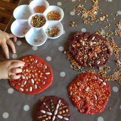 the child is making cookies with sprinkles and seeds on the table top