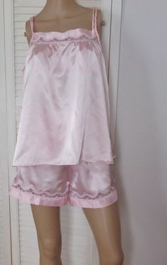 This is a vintage LovLee Shortie Pajamas, Pink Satin with Pink Lace Trims, Sleeveless Loose Top, Shorts with lace trim, Size M, 100% Polyester.  Top is slightly gathered at bust and back for a loose fit.  Narrow double straps. Though these pjs are marked size M, please compare your own measurements to those taken with garments laid flat, as I do not accept returns TOP: Chest 21.5 in. side to side Shoulder to hem 25 in. Hem 29 in. side to side SHORTS: Waist 13 in. side to side unstretched / 16 in. when stretched Hip 20 in. side to side Inseam 3 in. Waist to hem 14 in. Leg Openings 26 in. around These shortie pjs are well made, in very good condition, and though preowned, they look unworn.  Great loungewear. If you need help with your first purchase on Etsy, here is a helpful guide: http://w 80s Pajamas Vintage, Vintage Pajamas Aesthetic, Gyaru Pajamas, 80s Pjs, Vintage Pjs, Feminine Attire, 80's Clothes, Baby Doll Pajamas, Shorts With Lace Trim