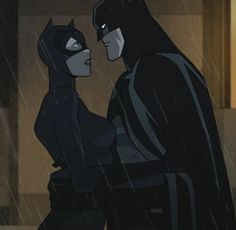 batman and catwoman standing in the rain