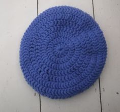 a blue crocheted dishcloth is laying on the floor