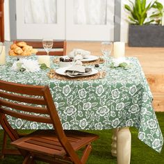 the table is set for two outside on the grass