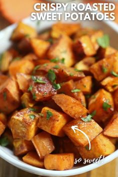 crispy roasted sweet potatoes with parsley in a white bowl on a wooden table