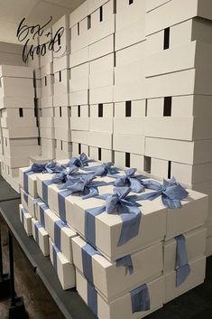 several boxes with blue bows are stacked on top of each other in a room full of white boxes