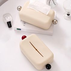 two pieces of white plastic sitting on top of a table next to glasses and other items