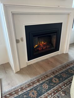 a fire place in a living room with a rug on the floor next to it