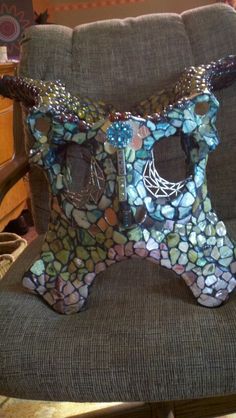 a chair that has some kind of animal on it's back legs and is made out of glass mosaics