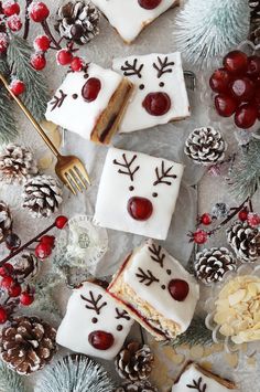 christmas desserts with white frosting and red berries on the table next to pine cones