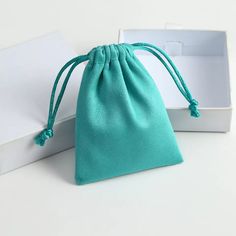 a white box with a blue bag inside it and a green string on the side