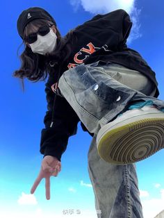 a person wearing a face mask doing a trick on a skateboard