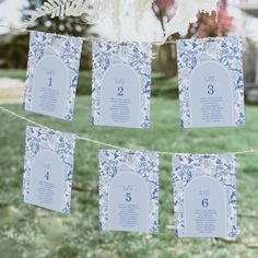 blue and white wedding seating cards hanging from a line