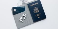 a passport, headphones and earbuds sitting on top of a card holder