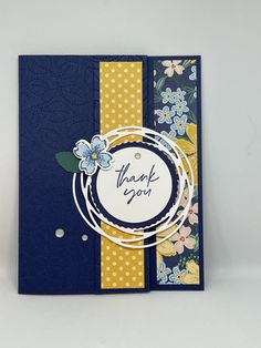 a thank you card with flowers and polka dots on the front, in blue and yellow