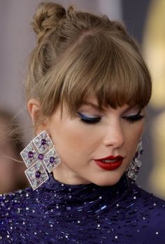 a close up of a person wearing earrings and a dress with sequins on it