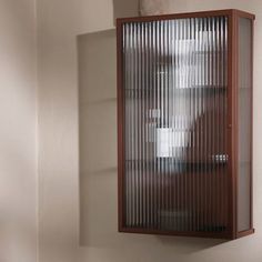 a wooden cabinet with glass doors on the wall