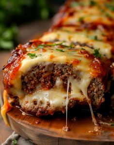 meatloaf stuffed with cheese and sauce on a wooden platter next to parsley