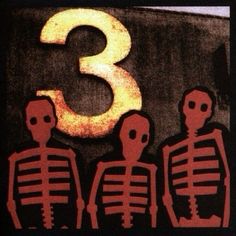 three skeletons standing in front of a number 3 sign