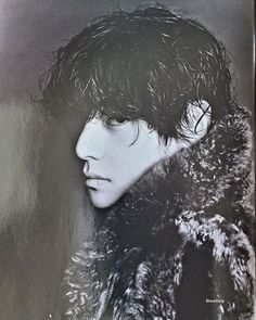 a black and white photo of a person wearing a fur coat with his head tilted to the side