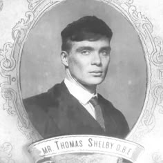 an old black and white photo of a man in a suit with a ribbon around his neck