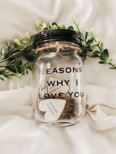 a jar filled with money sitting on top of a bed