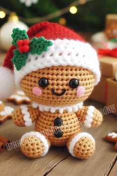 a small crocheted teddy bear wearing a santa hat on top of a wooden table