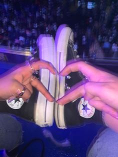 two people touching each other's shoes in front of a crowd at a concert