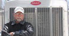 a man standing in front of a truck with his arms crossed