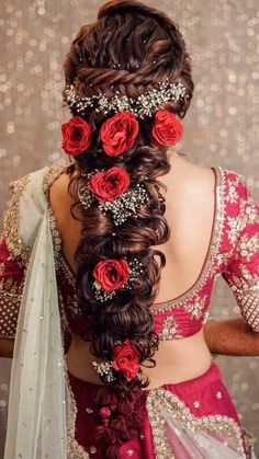 a woman with long hair and flowers in her hair, wearing a red sari