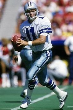 a football player running with the ball in his hand and people watching from the stands