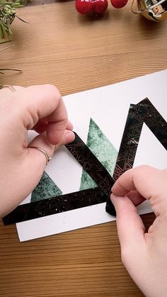 someone is cutting out the letter k with scissors on a piece of paper that has been cut into smaller letters