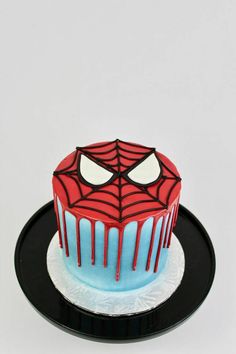 a spiderman cake on a black plate