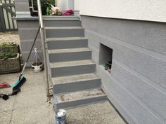 the stairs are painted gray and there is a can of paint on the ground next to them