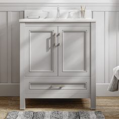 a bathroom vanity with two sinks and a rug on the floor in front of it