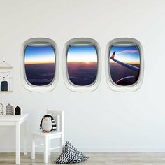 three windows in the wall above an airplane wing