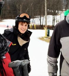 two men standing next to each other in the snow wearing skis and goggles