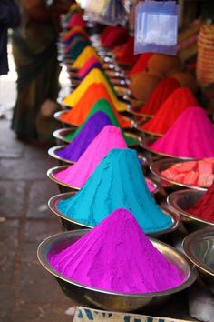 there are many different colored powders in bowls