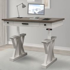 a desk with a computer on top of it in front of a window and white rug