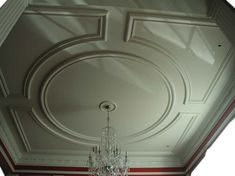 a chandelier hanging from the ceiling in a room with red and white walls