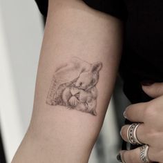 a woman's arm with a small tattoo of a bear and cub on it